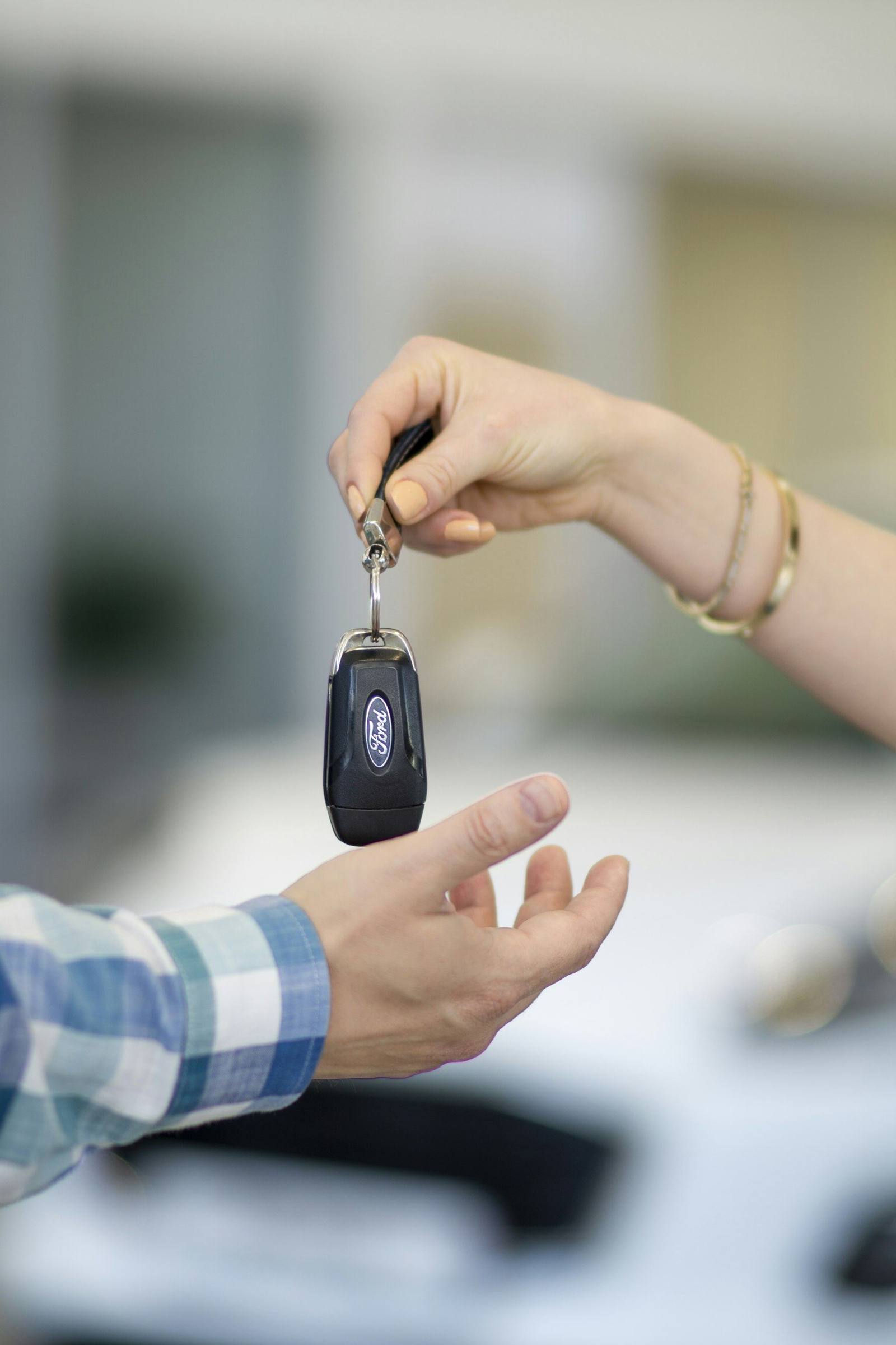 A salesperson handing car keys to a new owner